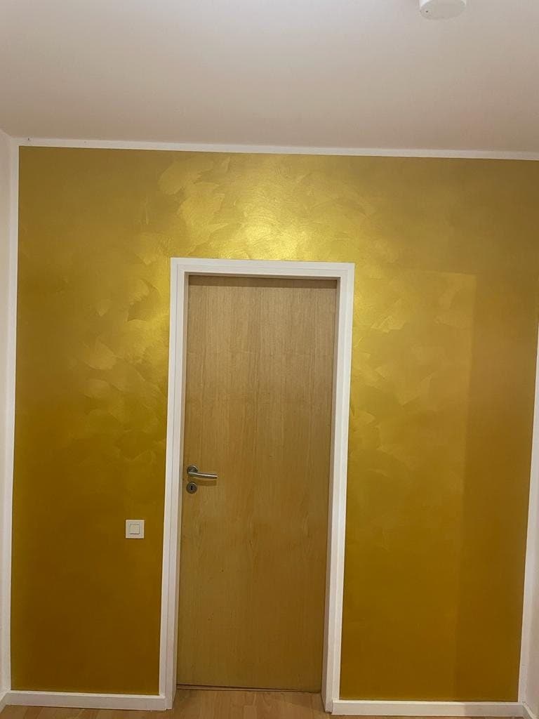 Wand in Goldtechnik mit Holztür